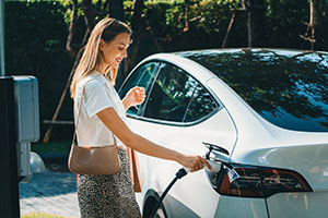 Frau lädt Elektrowagen